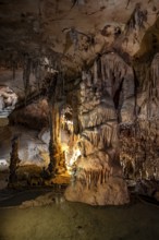Stalactites and stalagmites, rock formations in a stalactite cave with water basin, Grotta del