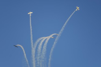 Stunt aerobatic planes performing stunts in blue sky with smoke trail. Concept of teamwork,