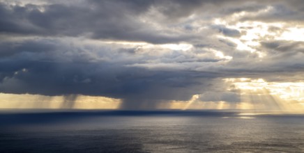 Sunset, sun rays over sea, dark rain cloud, rain, Madeira, Portugal