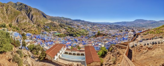 Panoramic picture of a city with distinctive blue buildings and mountainous surroundings, Morocco,