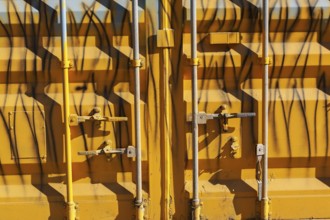 Close-up of locked doors on yellow painted metal boxed shaped shipping container, Quebec, Canada
