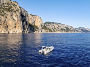 Motorboat off picturesque rocky coast ImmorgenLicht, cliffs, Golfo di Orosei, Baunei, Sardinia,