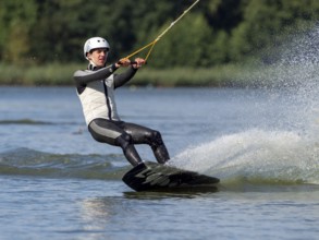 Young man with wakeboard, sporty on water, athletic model, active water sports, wake park