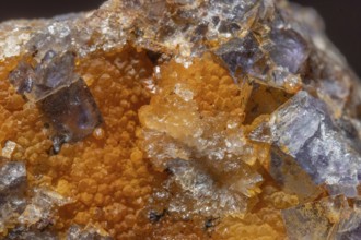 Shiny crystals of blue and orange color can be seen in this mineral formation. They are sparkling