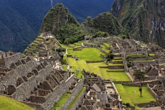 Ancient stone ruins and green terraces against a mountain backdrop, The ruins of the Inca city of