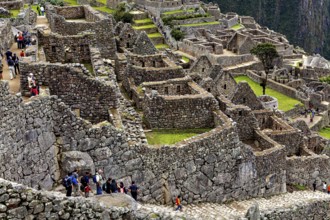 Tourists explore the well-preserved stone ruins of Machu Picchu, the ruins of the Inca city of