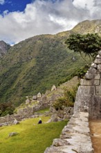 Stone terraces of Machu Picchu with surrounding green hills and blue sky, The ruins of the Inca