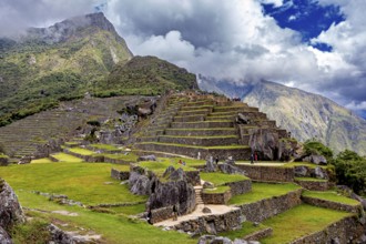 Terraced Inca landscape against dramatic clouds and mountains in Machu Picchu, The ruins of the
