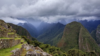 Dramatic mountain landscape with clouds and lush greenery interspersed with fog, The ruins of the