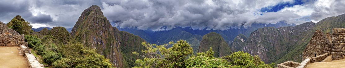 Panoramic view of dramatic mountains and wooded slopes under a cloudy sky near Machu Picchu, The