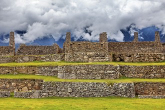 Stone ruins on several levels with mountains and clouds in the background, The ruins of the Inca