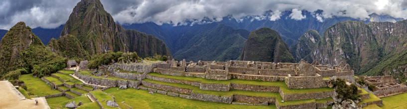 Wide view of Machu Picchu with stone terraces and clouds in the sky, The ruins of the Inca city of