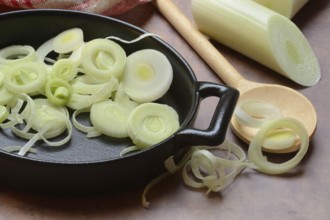 Leeks, leek rings in pan with cooking spoon, leek