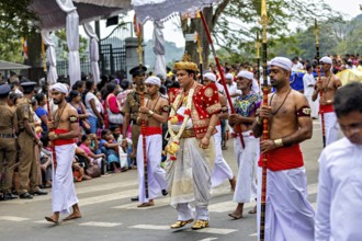 Man in royal dress leads a ceremonial procession at a cultural event, The Perahera Parade in Kandy