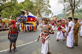 Lively festival parade with dancers, an elephant and a large crowd of spectators, The Perahera