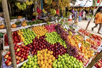 Colourful variety of tropical fruits on a lively market stand, dealers in the market halls of Kandy