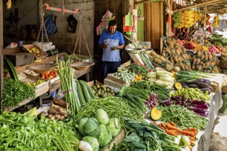 A variety of fresh vegetables on a busy market stand, dealers in the market halls of Kandy Sri