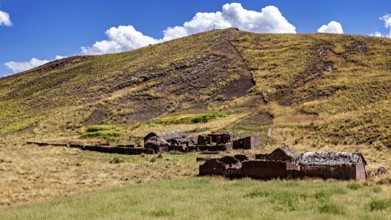 Ruins on a hill in a grassy landscape under a cloudy sky, The landscape in the highlands of Peru