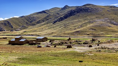 Small houses at the foot of mountains in a vast landscape under blue sky, The countryside in the