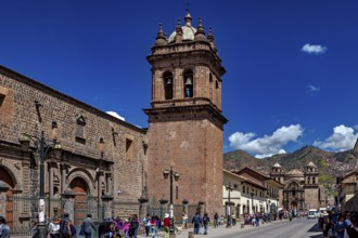 Bell tower on a historic street with people and mountain scenery under clear skies, The churches of