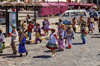 People wearing colorful costumes on a street at a parade, traditional parade of festival groups in
