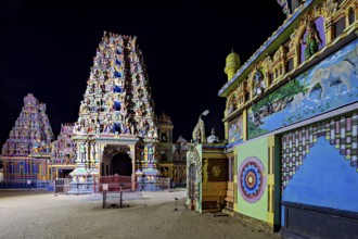 Colourfully illuminated temple complex with complex architecture and wall paintings at night, The