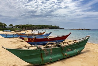 Beach with colorful fishing boats in the sand against a cloudy sky and calm sea, Traditional boats