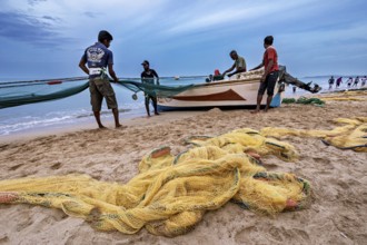 Fishermen on the beach catch up with nets, the sea is calm and the sky is cloudy, Traditional
