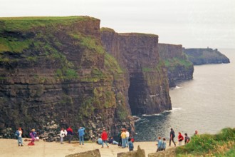 People on the cliff edge, there was no fence back then, Cliffs of Moher, County Clare, Republic of