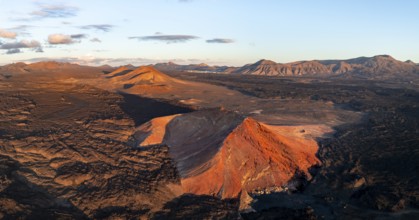 Picturesque volcanic landscape in evening light, red volcano Montaña Bermeja between lava fields,