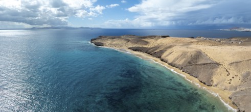 Coast with Playa Caleta del Congrio beach and blue sea, arid landscape of Los Ajaches Natural Park,