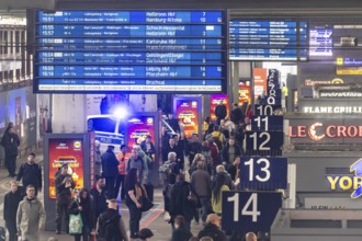 Travelers at the main train station, passengers and departure board at Stuttgart main station.