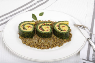 Southern German cuisine, polenta spinach roulade with alblentils served on serving platter, bay