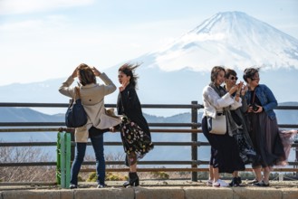 Tourists enjoy the view and take pictures, view of the snow-covered summit of Mount Fuji volcano in