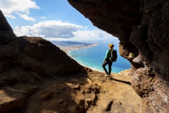Tourist in the Cueva de las Cabras cave, young woman enjoying the view from the Risco de Famara