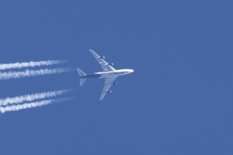 Boeing 747 jumbo jet cargo aircraft of Atlas air airlines flying in a blue sky with contrails or
