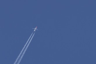 Boeing 737 jet passenger aircraft of Norwegian Air airlines flying in a blue sky with contrails or