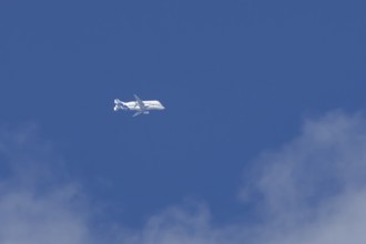 Airbus A330-743L Beluga XL cargo jet aircraft flying in a blue sky with white clouds, England,