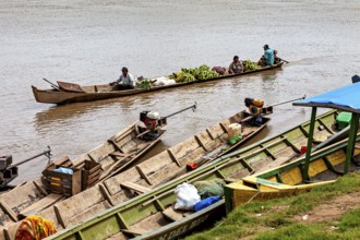People in wooden boats with bananas and engines on the river, longboat on a river near Rurrenabaque
