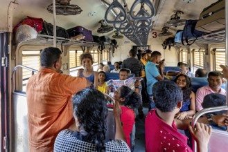 Passengers in a full train compartment, relaxed atmosphere, people talking and sitting, train ride