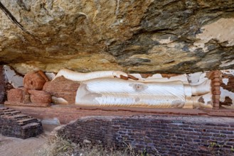Reclining Buddha embedded in a rock wall, made of sandstone, peaceful and meditative atmosphere,