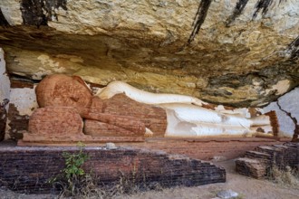 Ancient sandstone sculpture of a Buddha reclining under a rocky outcrop, tranquil setting, The