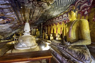Cave with several Buddha statues and wall paintings, central stupa in a spiritual setting, The cave