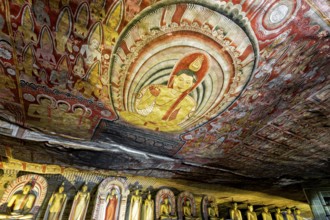 Ceiling painting in a cave with detailed Buddhist representations in strong colors, The cave