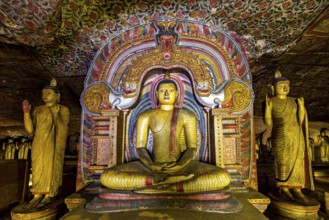 Central Buddha in a richly decorated frame within a cave decorated with ornaments, The cave temples