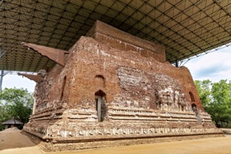 Large antique brick building under a modern roof structure, The temples of Polonnaruwa in Sri Lanka