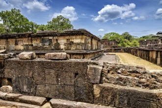 Massive ancient stone walls at a ruined site under a blue sky, The Temples of Polonnaruwa in Sri