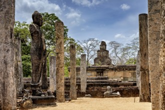 Ancient stone statue and pillars surrounded by ruins and an open landscape, The temples of