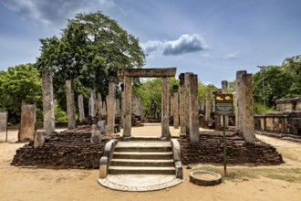Entrance with ancient columns and sandy soil under a partly cloudy sky, The temples of Polonnaruwa