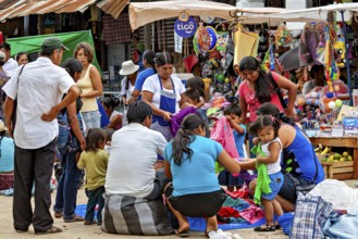 A group of families happily shop at a lively market, The Rurrenabaque Market in Bolivia
